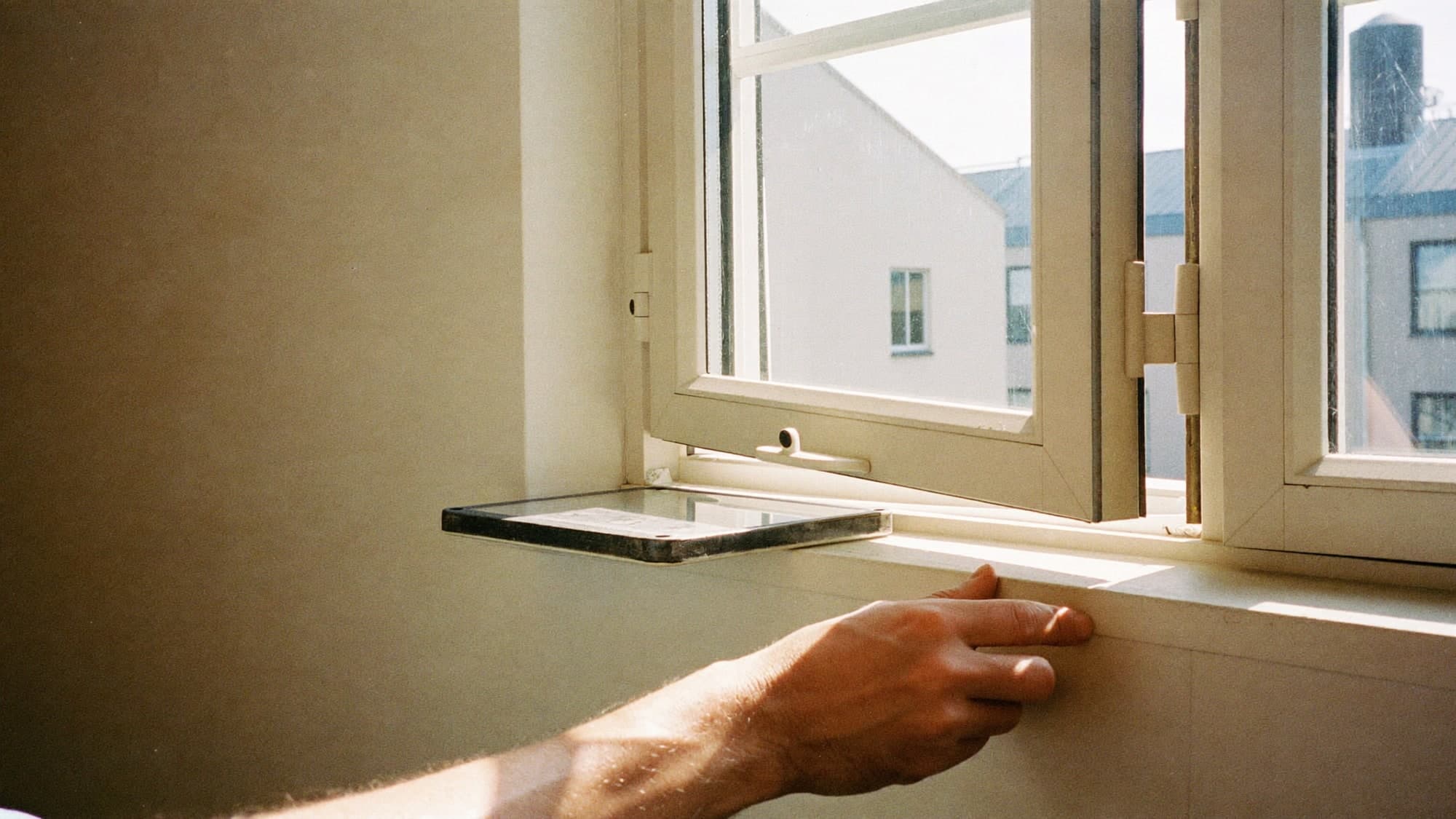 A surveyor checking the condition of a window frame in a flat.