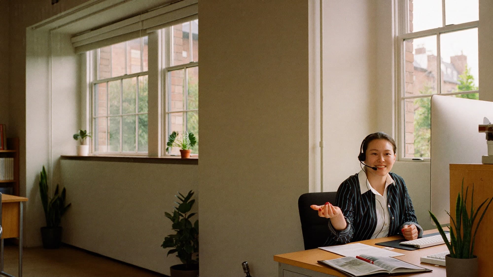 A colleague on a call in a bright office, mid-conversation.