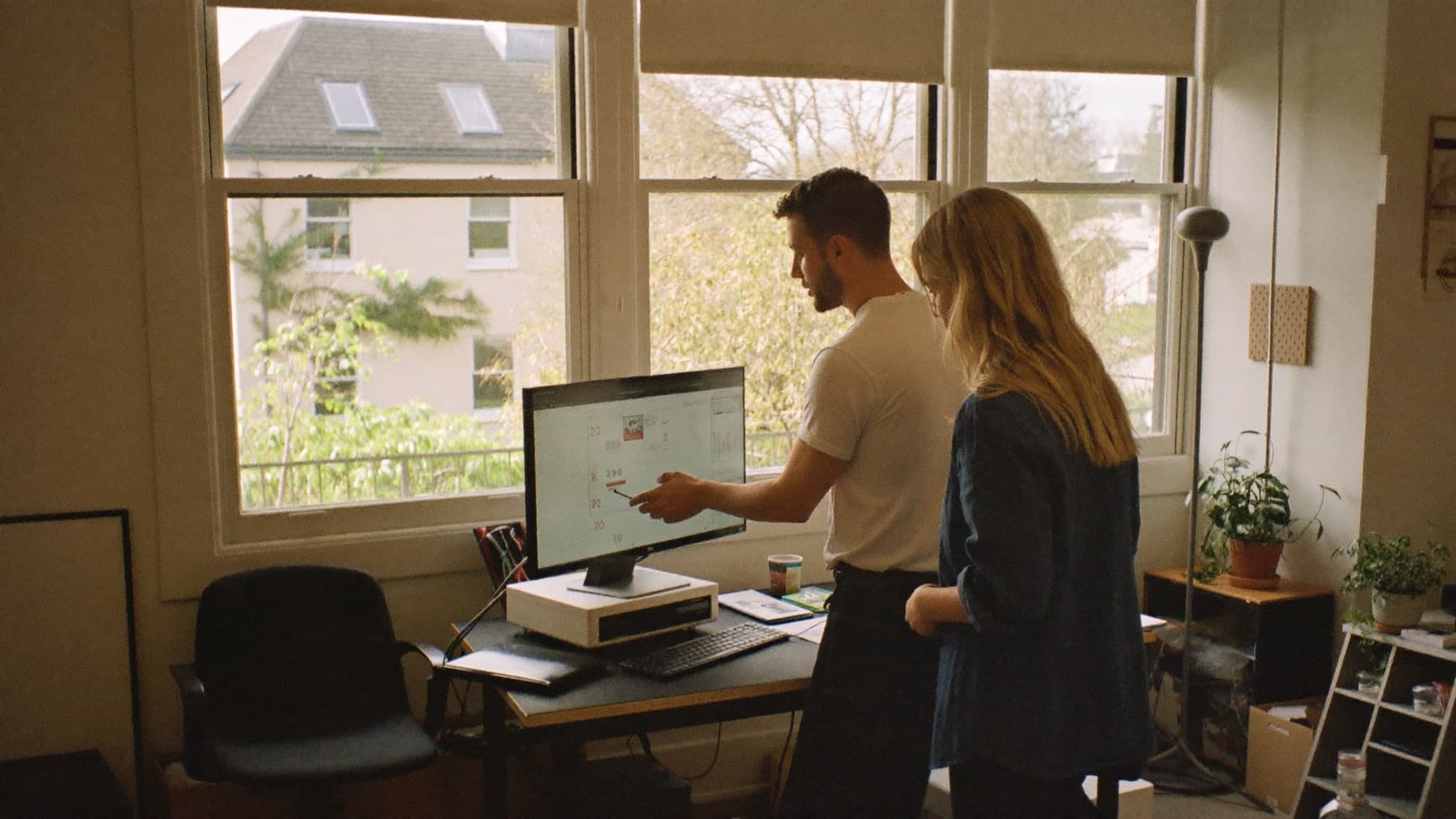Two colleagues reviewing figures together at a screen.